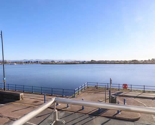 Balcony with seating and coastal views at Sea Breeze Retreat Pwllheli